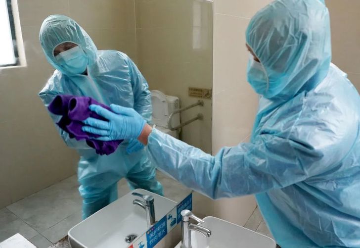 ↑ 2月8日，蘇啟云在公廁內(nèi)擦鏡子。今年54歲的蘇啟云是武漢市眾多“守廁人”中的一個(gè)。他負(fù)責(zé)武展東路公共廁所的保潔和消毒。