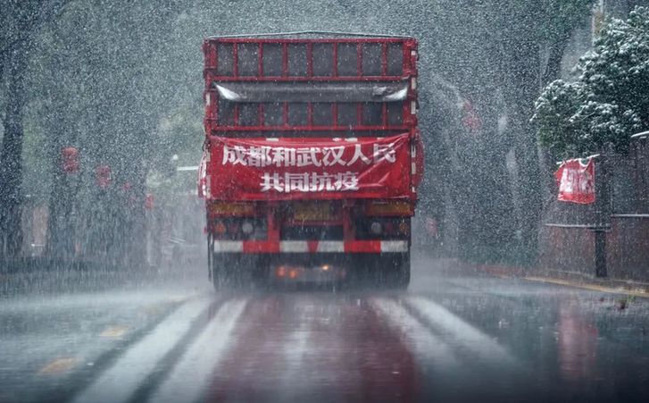 ↑ 2月15日，風(fēng)雪中，運(yùn)送成都市成華區(qū)捐贈(zèng)武漢消毒液的卡車在市區(qū)行駛。